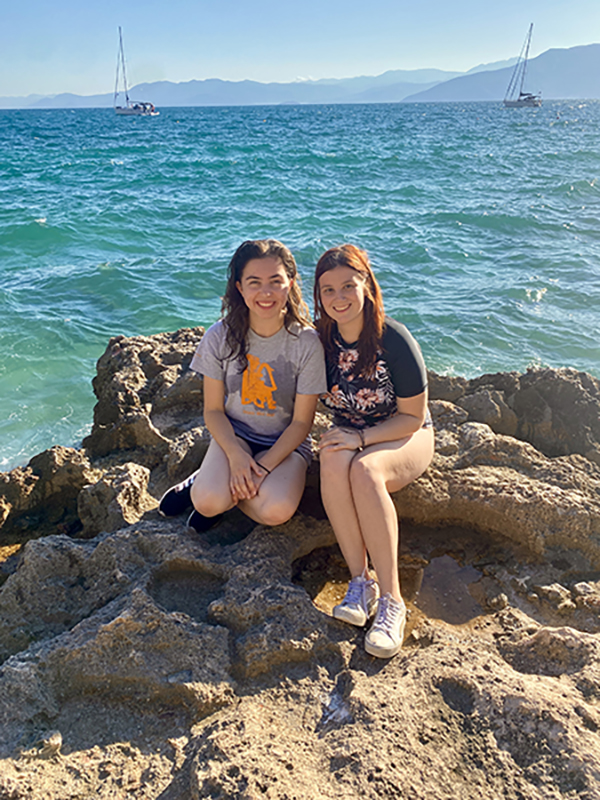 Two girls sitting on the shore of the Aegean Sea