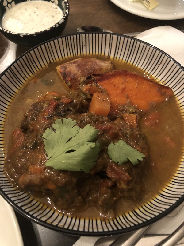 Bowl of stew in shallow bowl on table