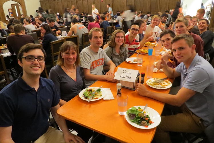 A group of people in the Whitman Dining Hall with a sign that says "Cena Latina" (Latin Dinner)