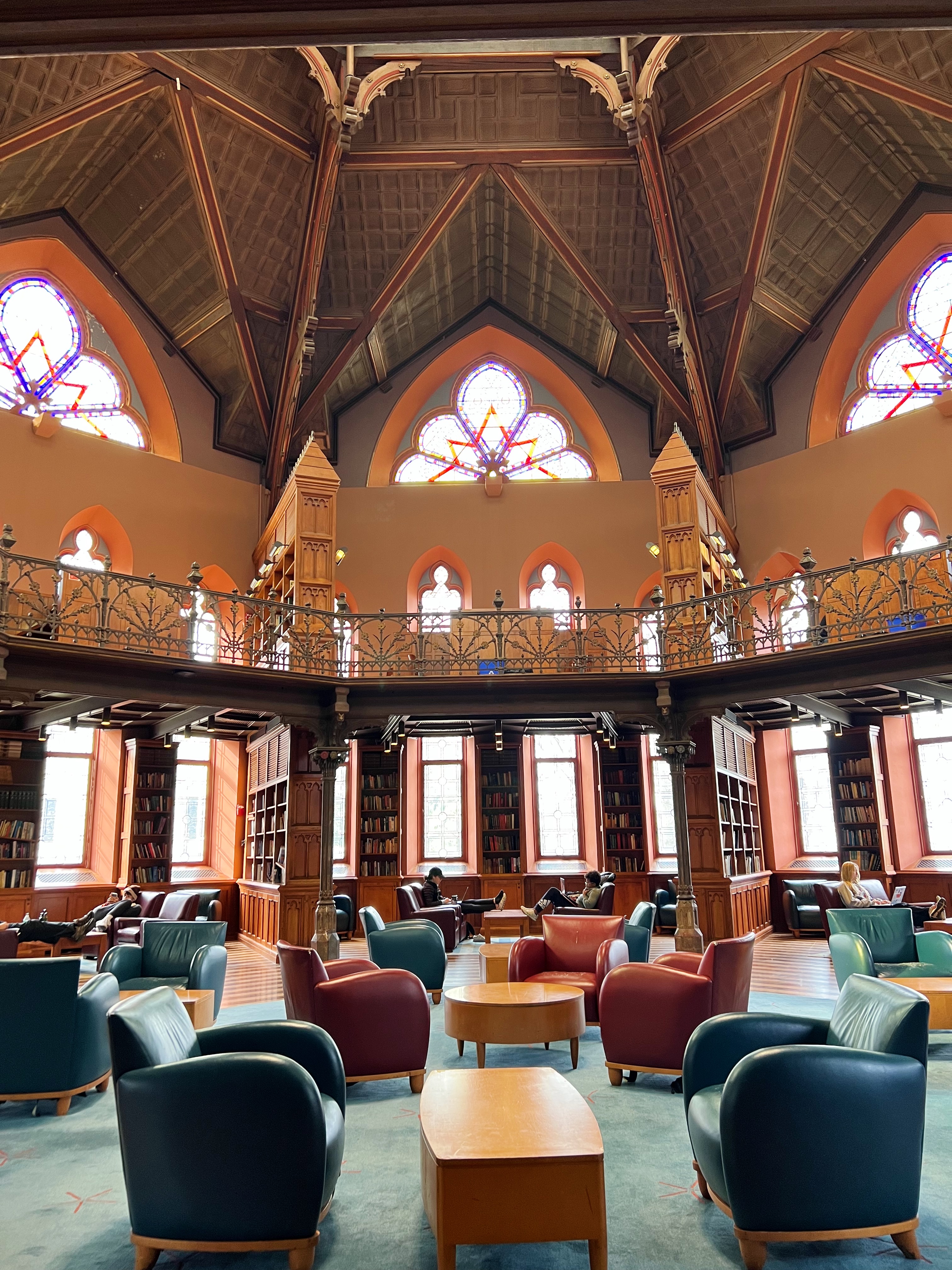 rotunda with ornate ceiling and stained glass windows, filled with arm chairs and coffee tables