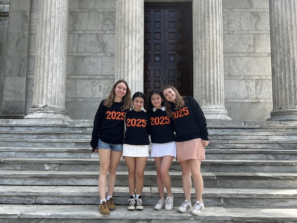 Four females students with 2025 sweaters posing on the steps of Clio Hall