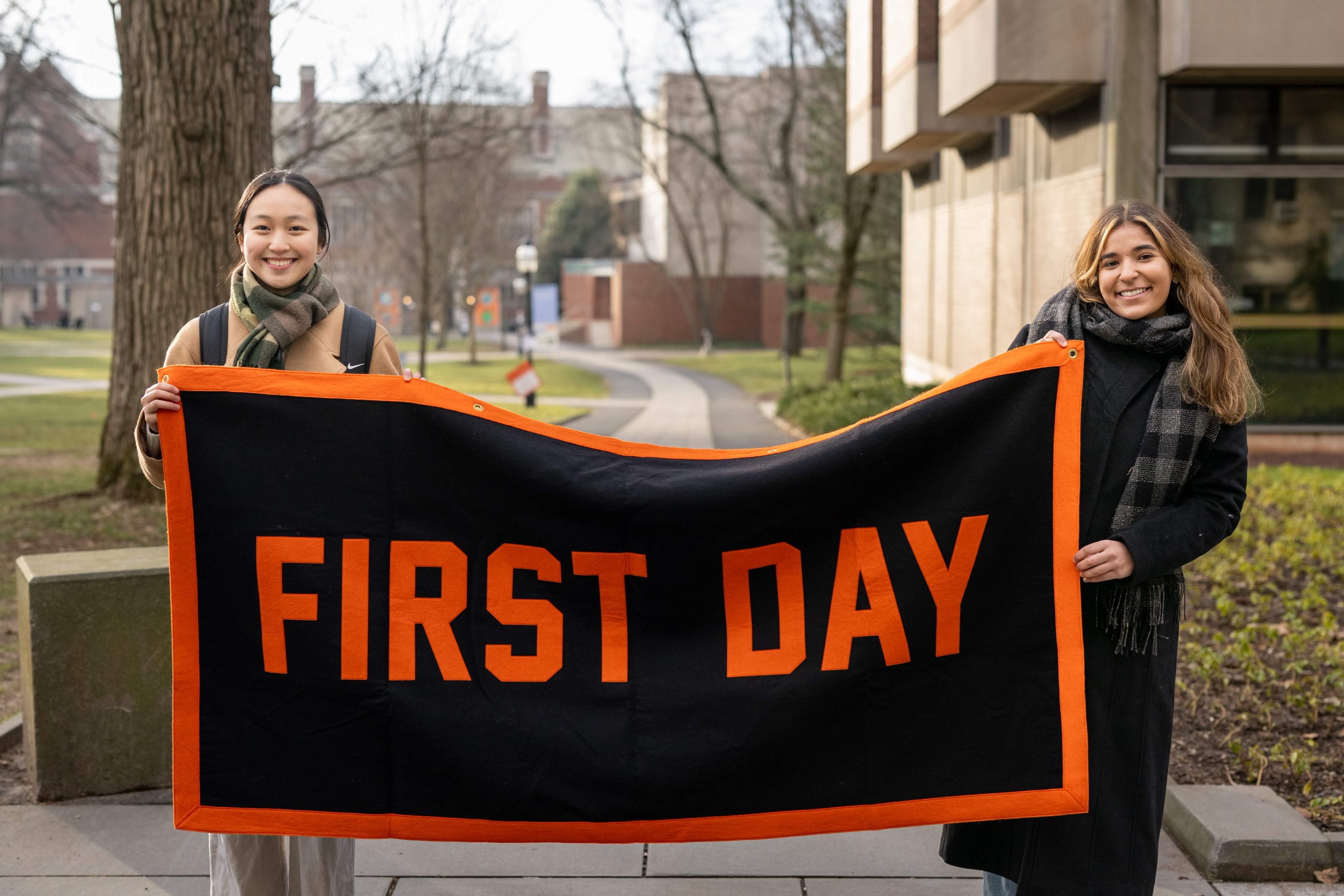 Two girls holding a banner that says "First Day"