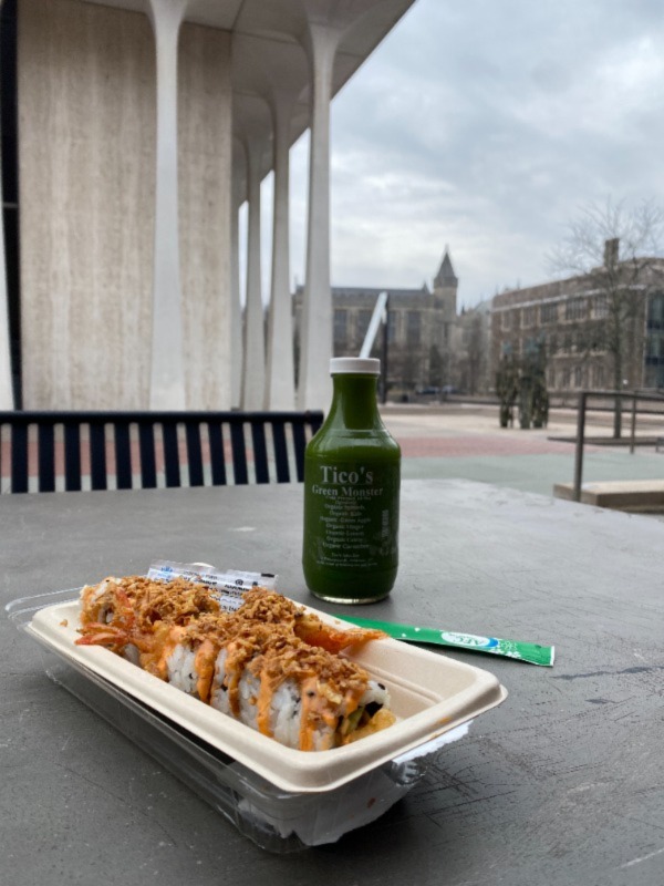 Photo of Tico's juice and sushi roll with SPIA building in background.