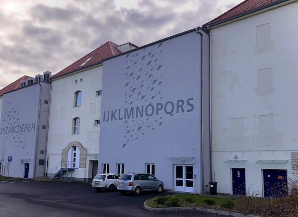 A large building with letters of the Czech alphabet on the side -- the central depository of the Czech National Literary Archives.