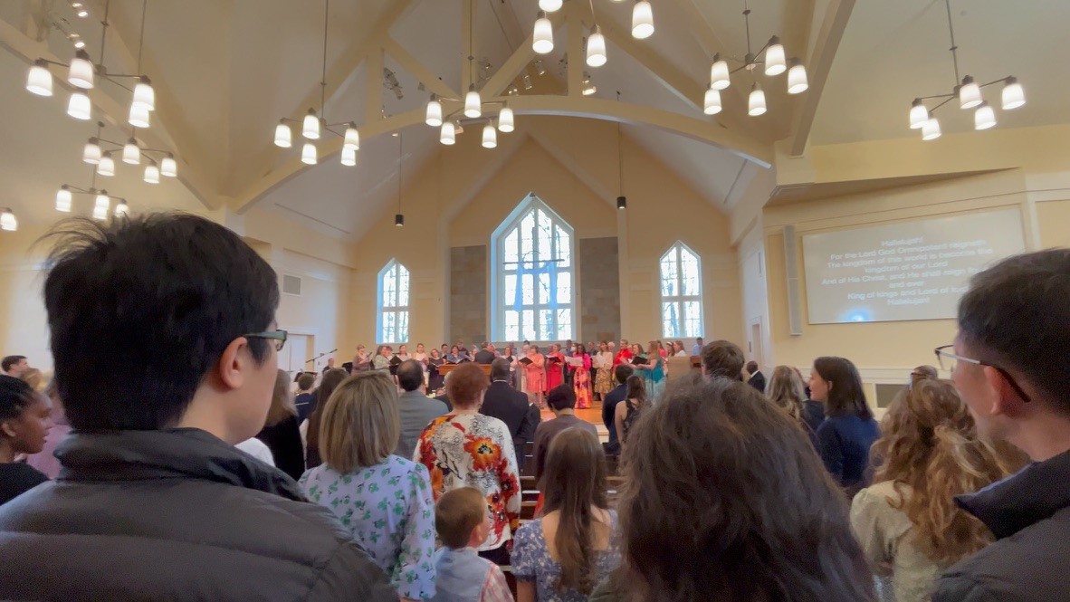 photo looks over a full church congregation, a choir stands on the alter