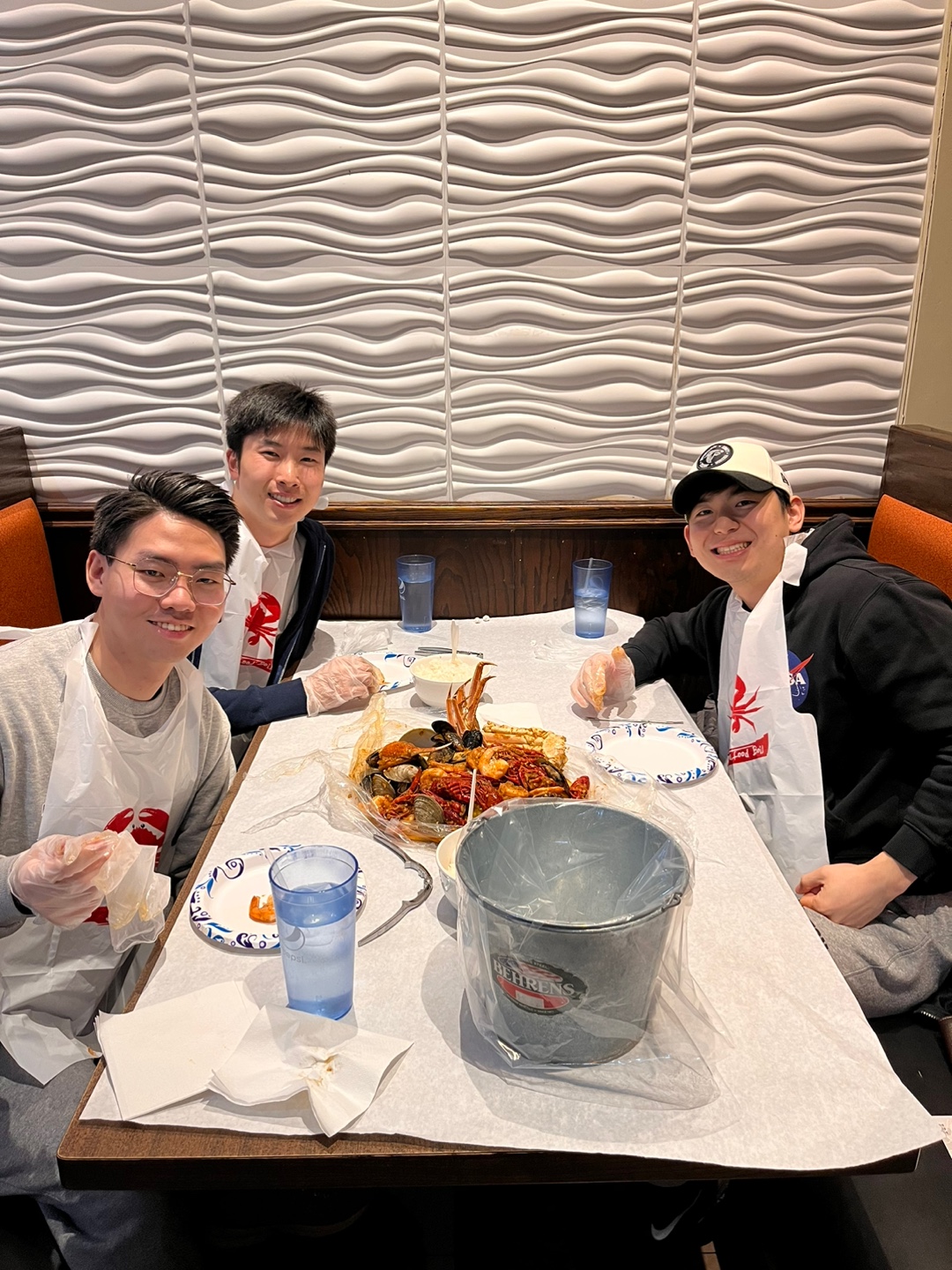 Three people sit around a table in a restaurant booth