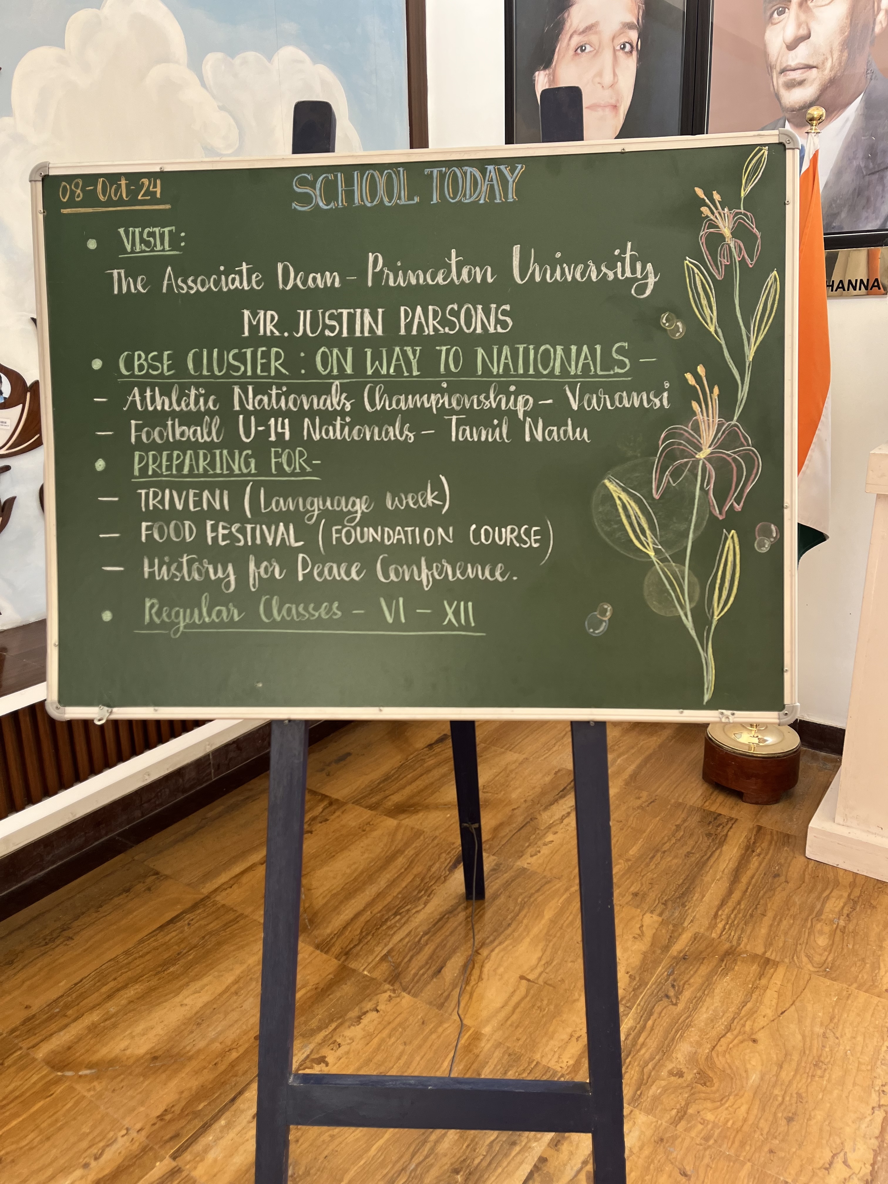 Chalkboard on an easel shows the school's events for the day including a visit from Princeton University admission officer