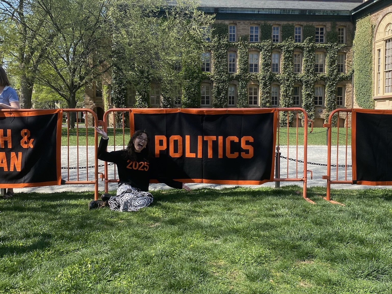 Student smiles while sitting in front of Politics Department banner.