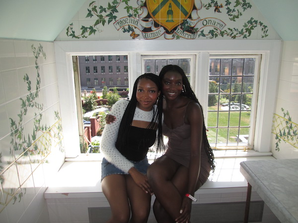 Two girls sitting in a bay window, smiling