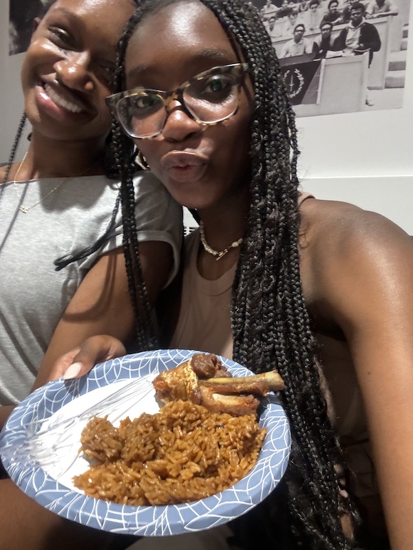 Two girls posing with a plate of food.