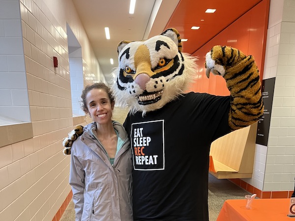 Author smiling with Campus Rec tiger mascot