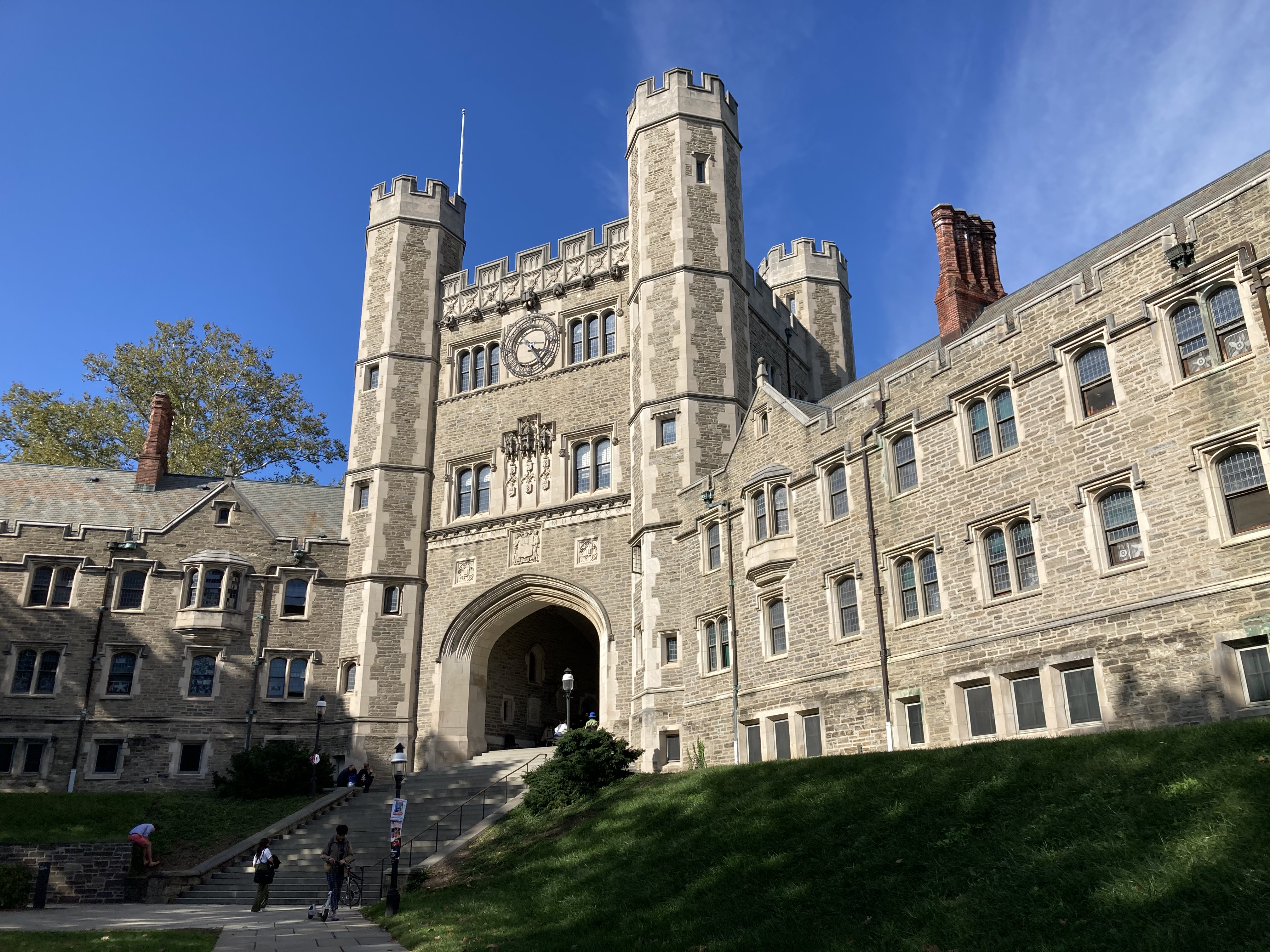 Photograph of a grey bricked gothic arch with stairs, Princeton University campus