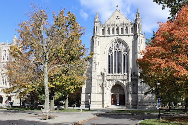 Two fall trees flanking the stone facade of the University chapel