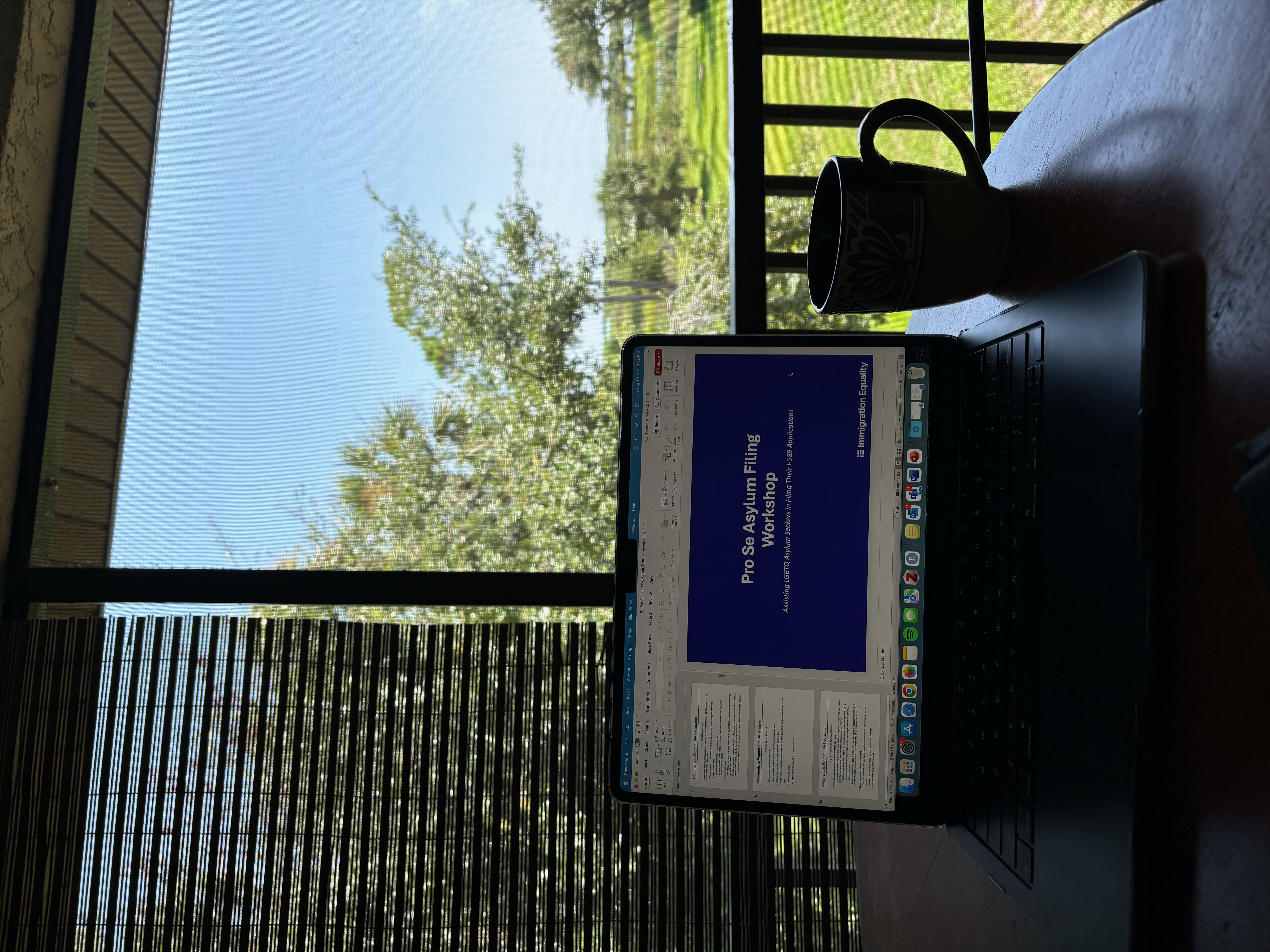 A cup of tea next to a laptop showing a presentation slide.