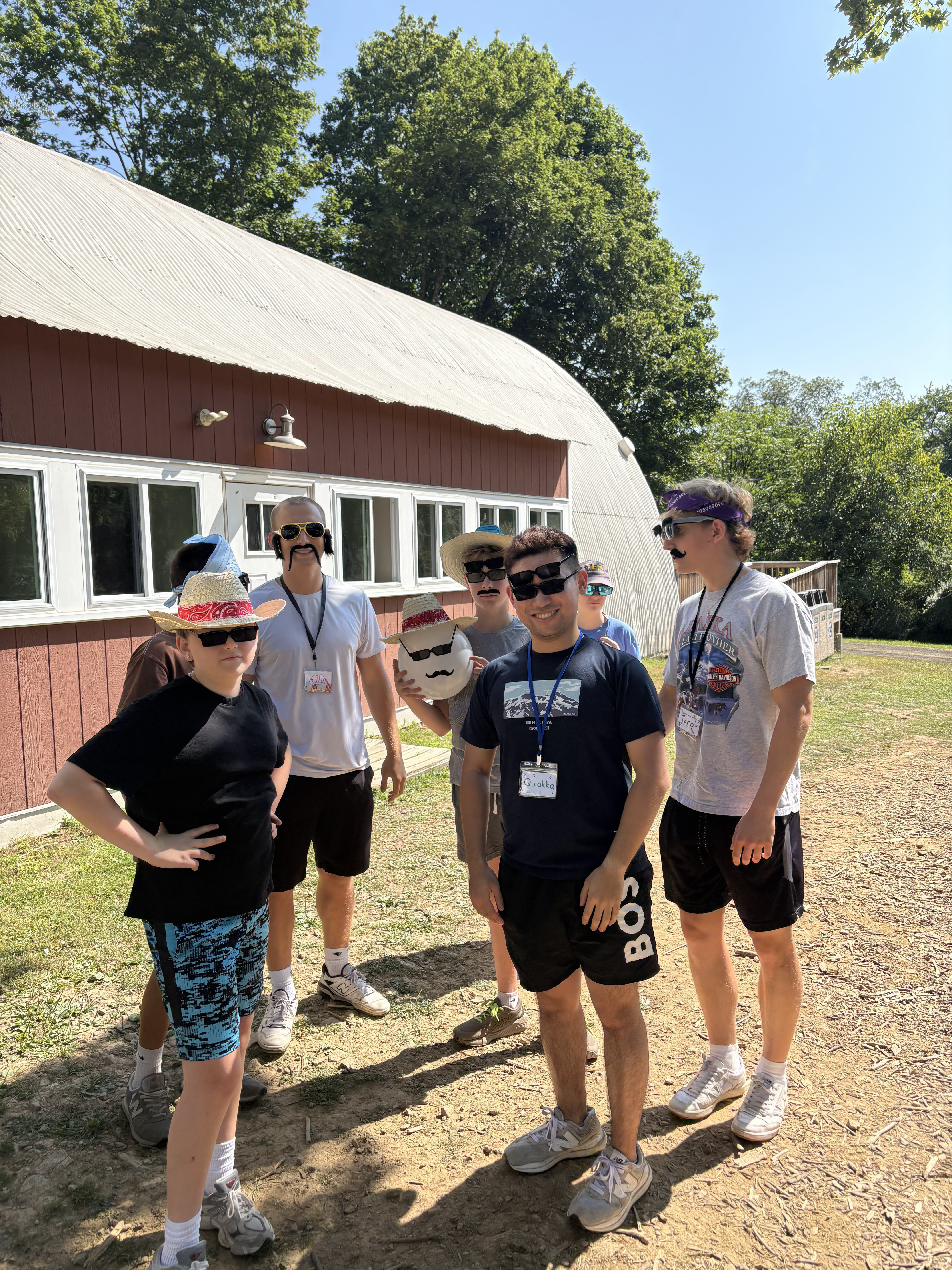 Some kids and counselors wearing hats and sunglasses for a fashion show