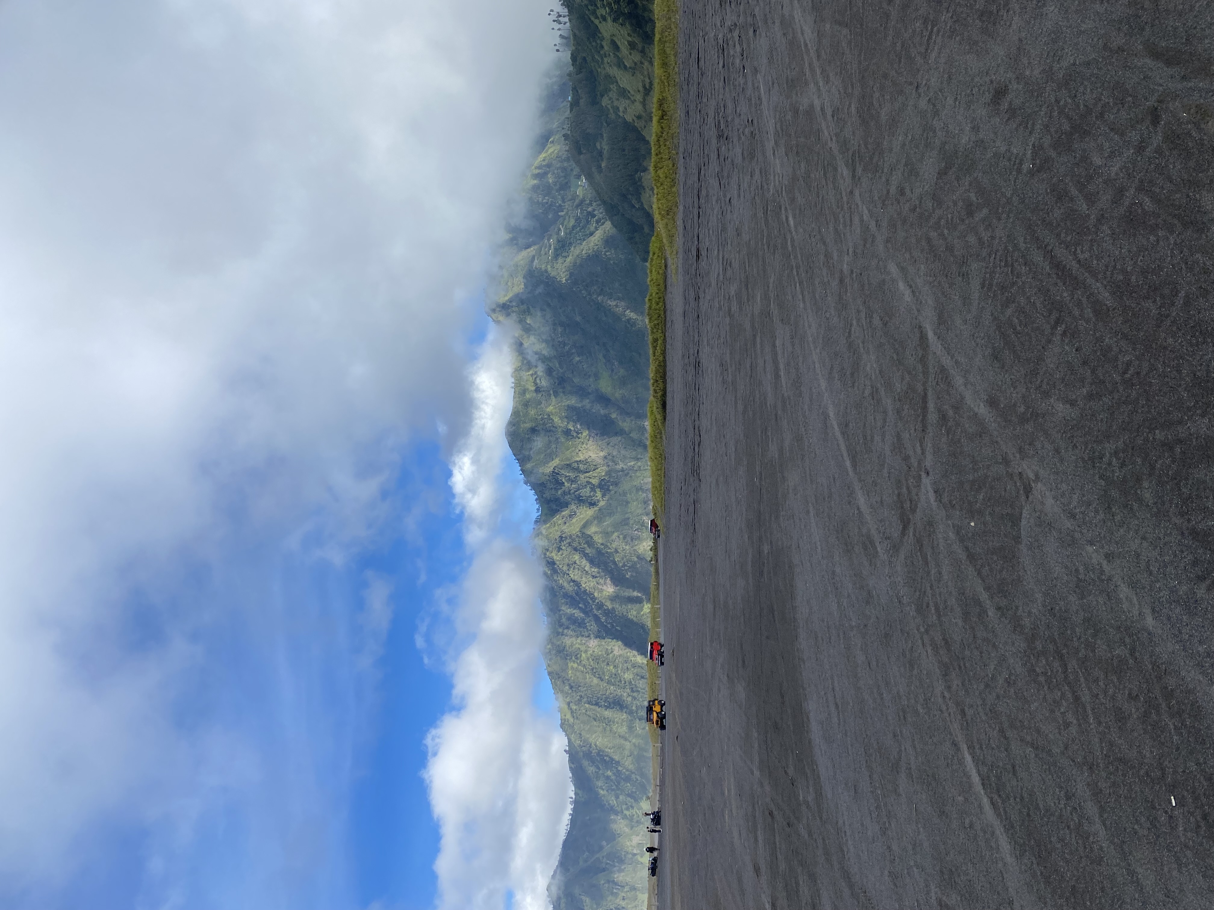 Ash valley at Mount Merbabu, off-roading vehicles in the distance