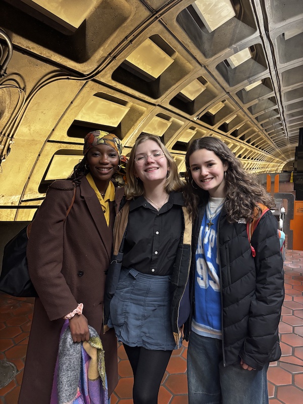 Three girls posing for a picture at a metro station