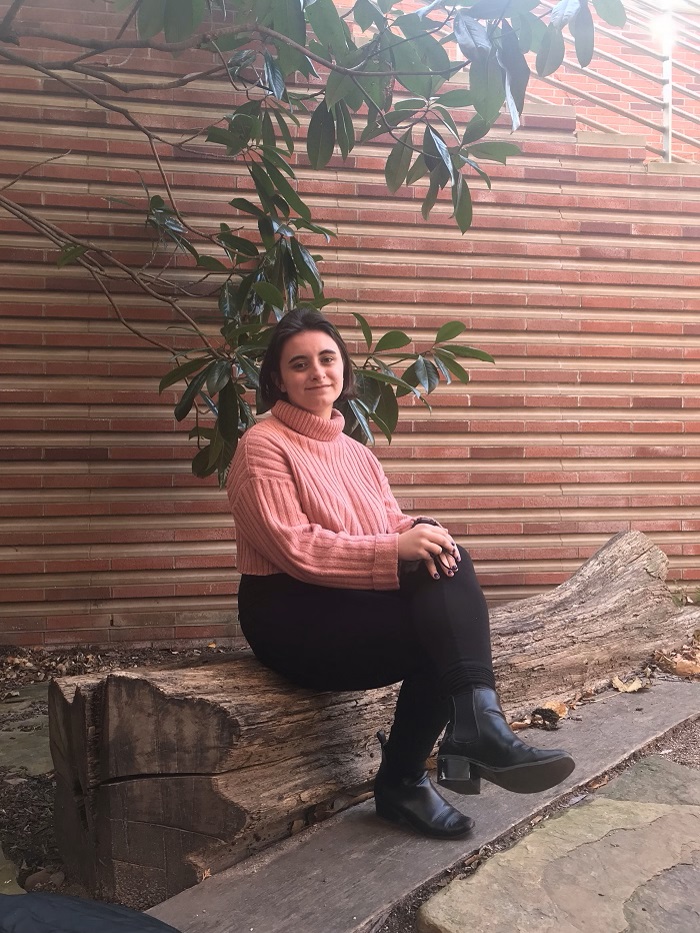 Izabela Konopka sitting on a tree trunk