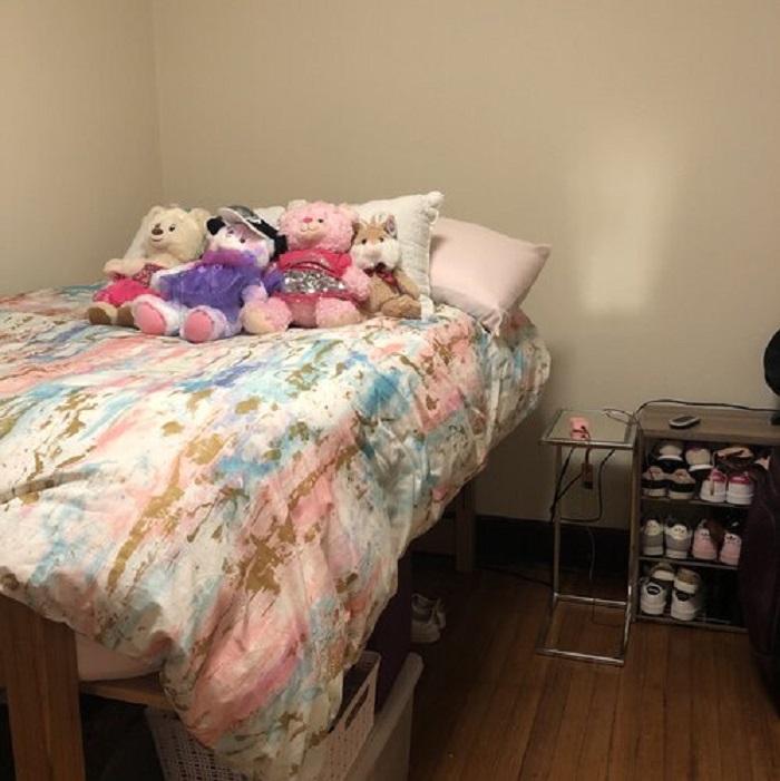 MIa's dorm room bed with a cluster of stuffed animals in the middle