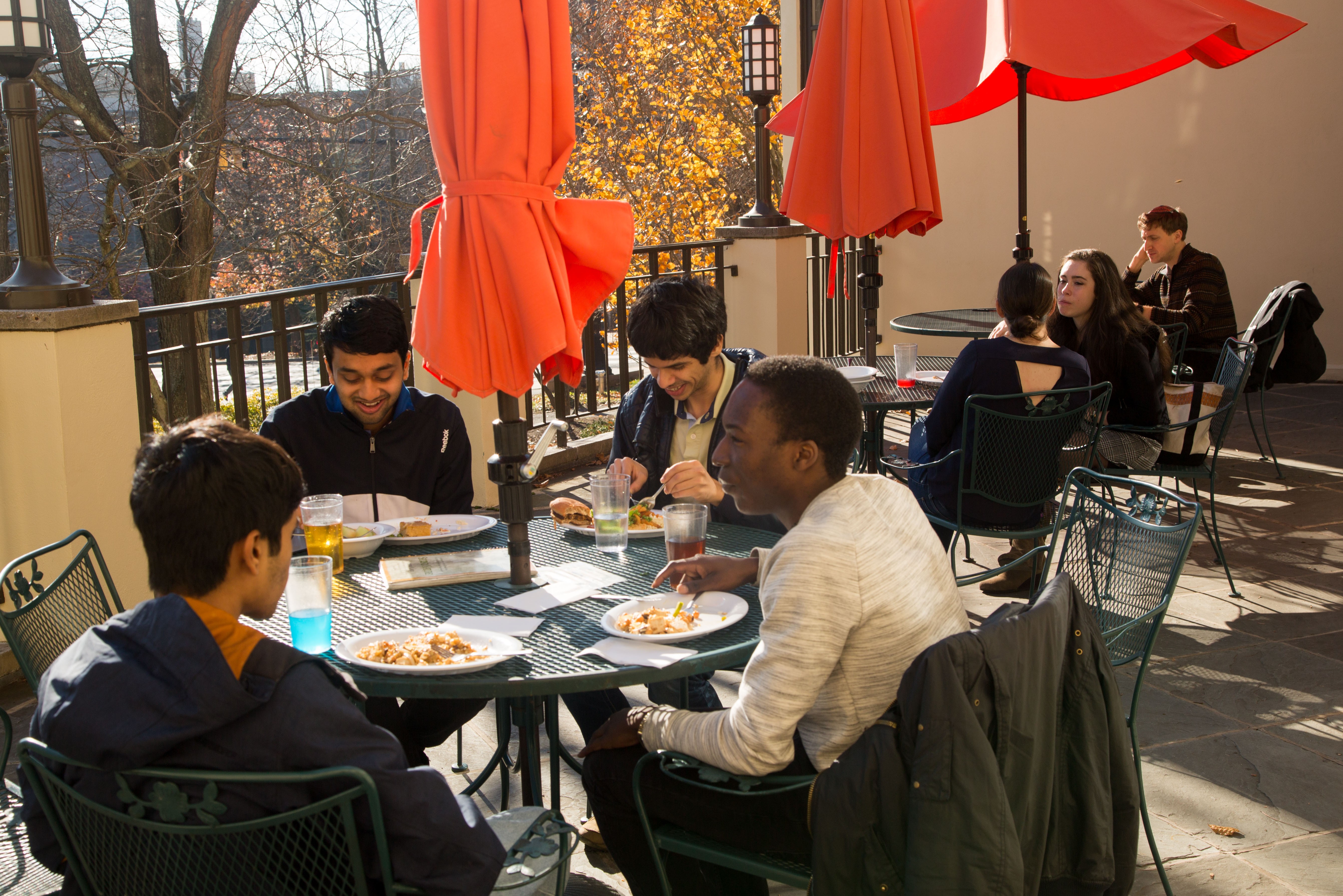 Students eating outside on a terrace.