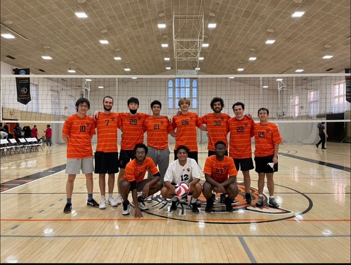 11 volleyball players posing on the court