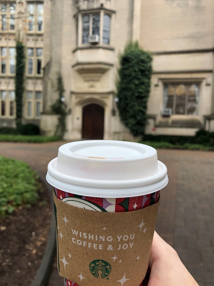 Starbucks holiday drink with a University building in the background