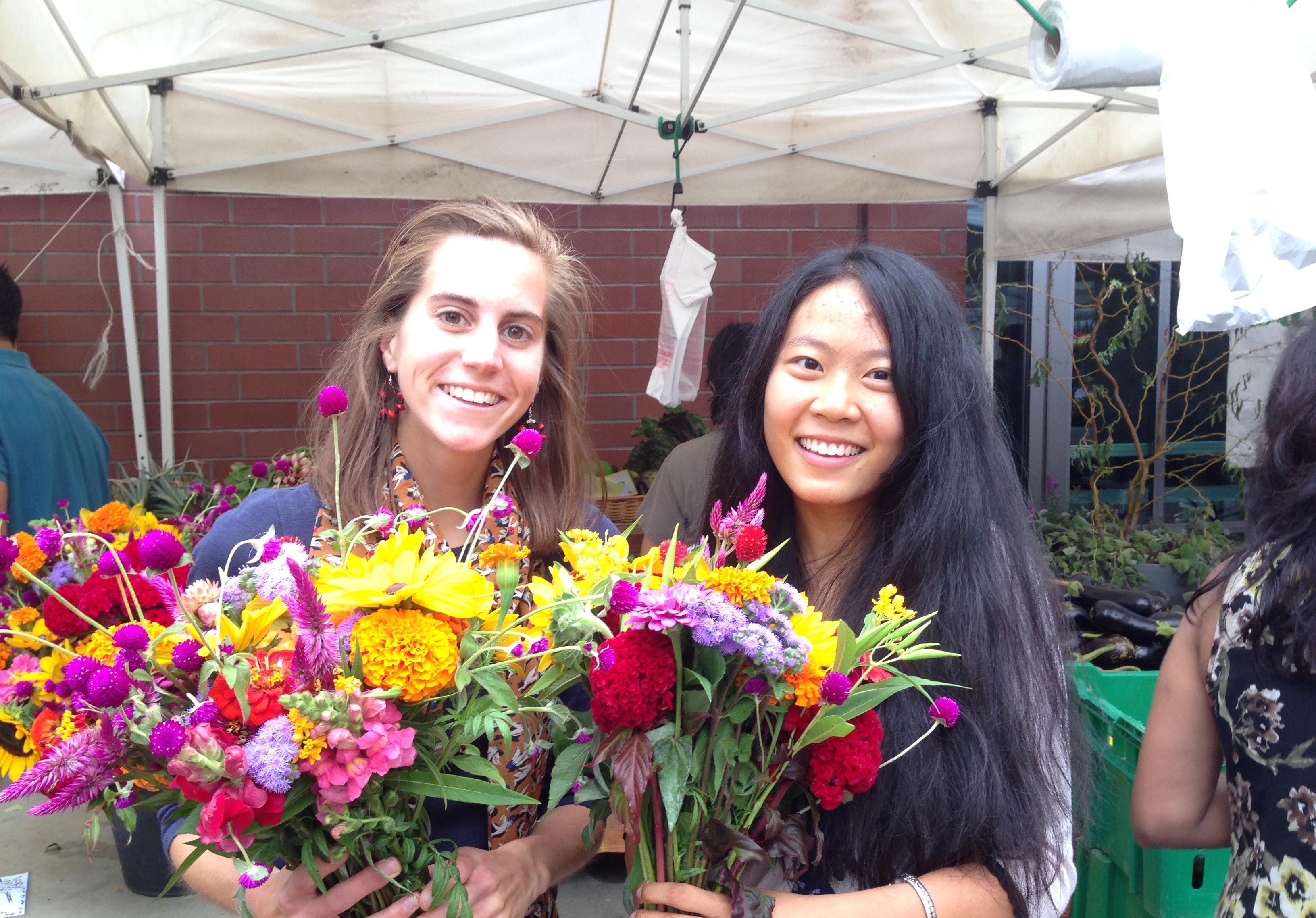This is a photo of my friend and me with flowers from the farmer's market.