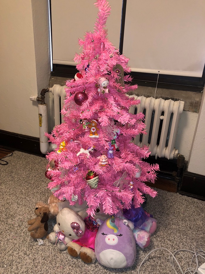 Pink Christmas tree with ornaments and stuffed animals underneath