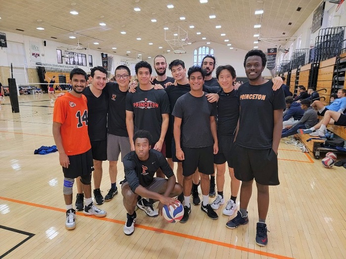 11 volleyball players posing on the court