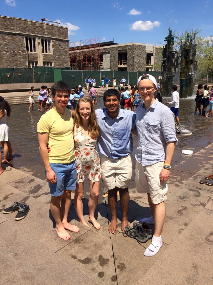 Three boys and a girl in front of a fountain