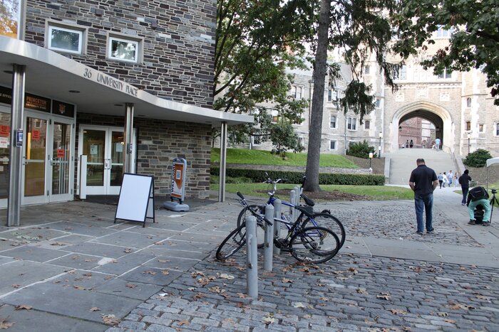 bicycles parked outside of university store, with Blair Arch in background