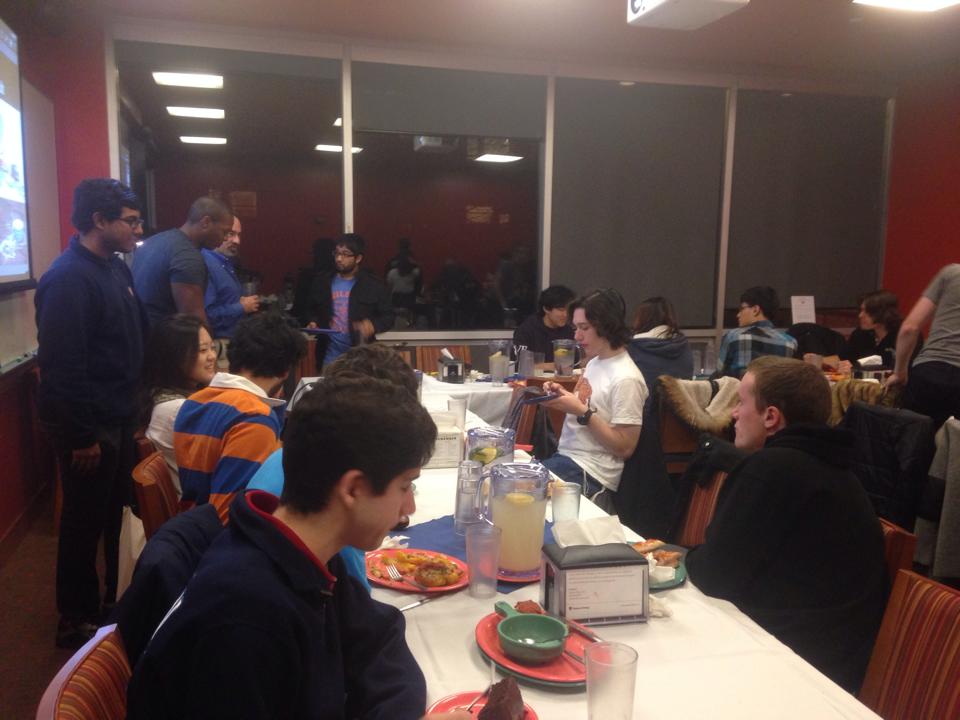 Students among each other and with Prof. Spergel in a dining room