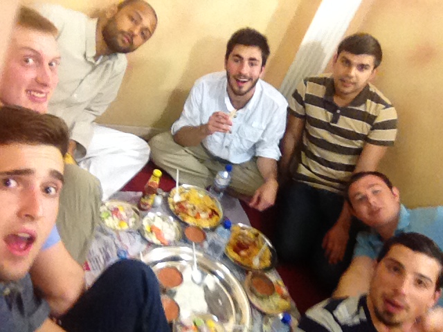 Several young men, including yours truly, crowded around a plate in a very cramped dining area.