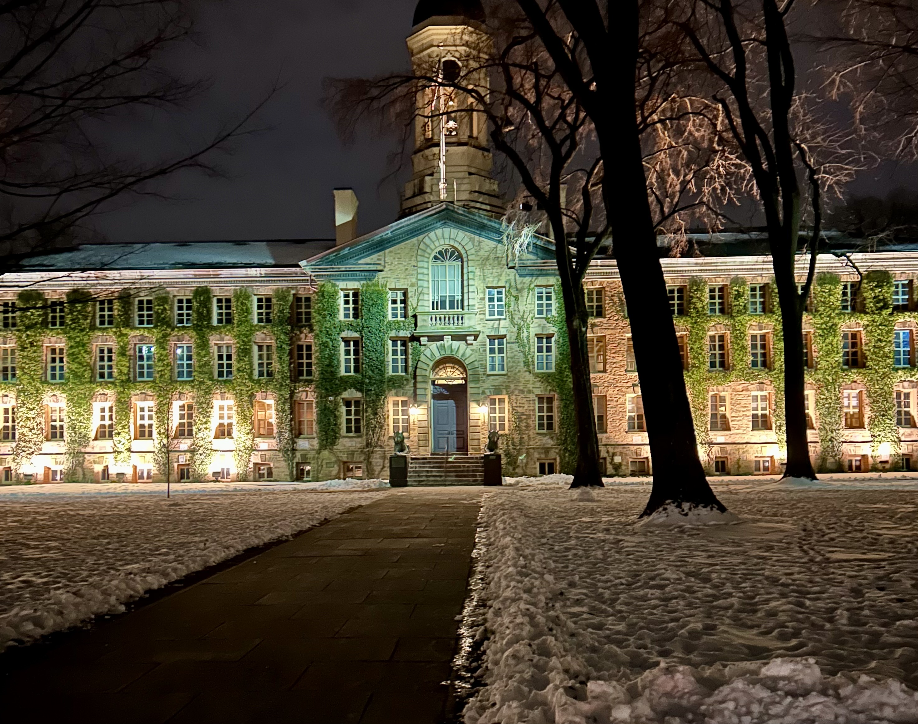 Nassau Hall at night with snow on the ground