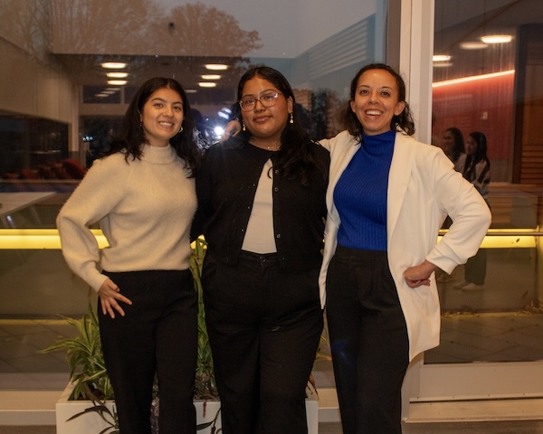 Three women standing near a window.