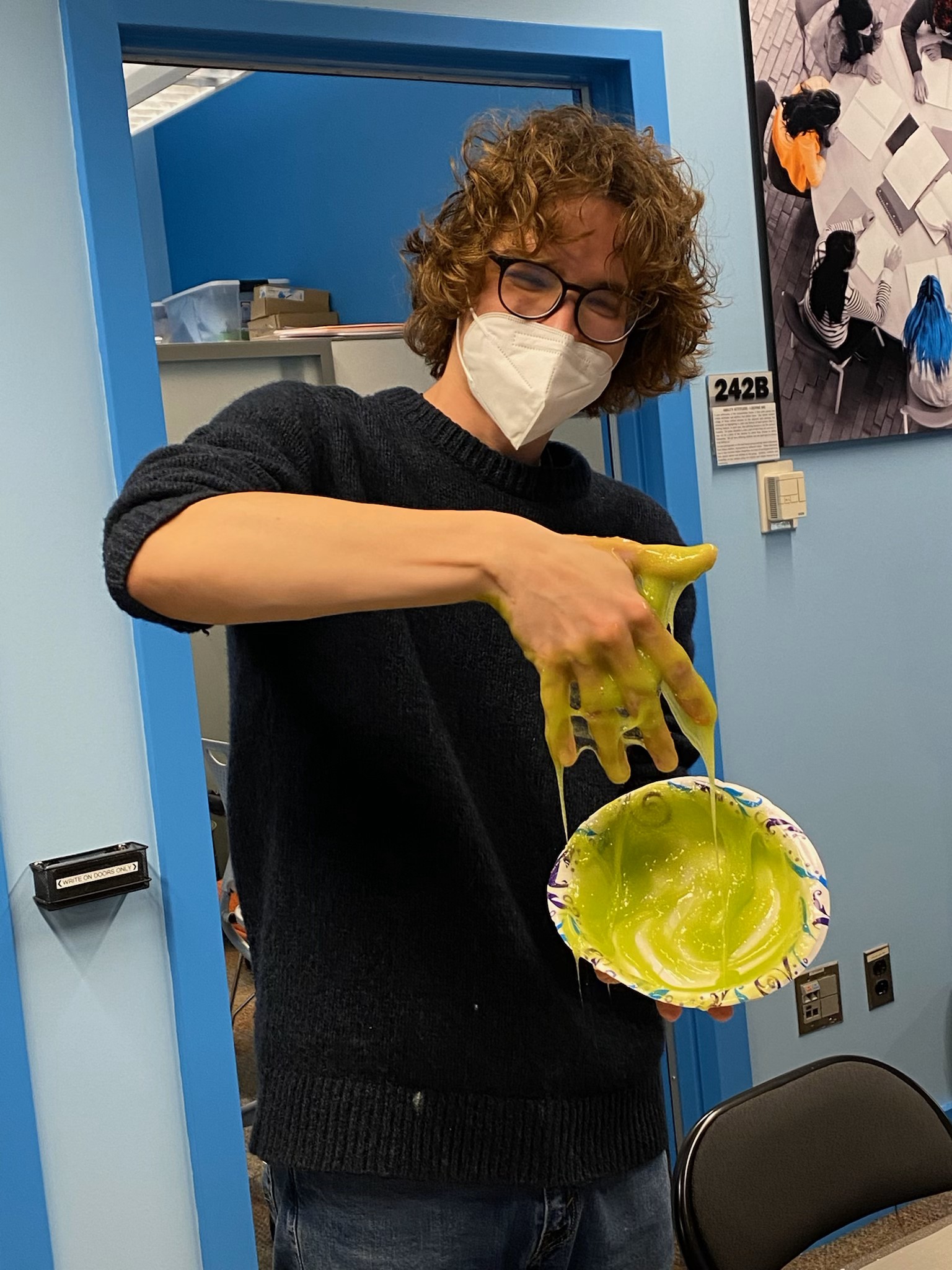 Harper poses with his hand in a bowl of slime