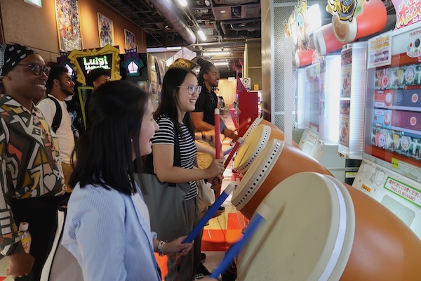 students playing drum game at arcade