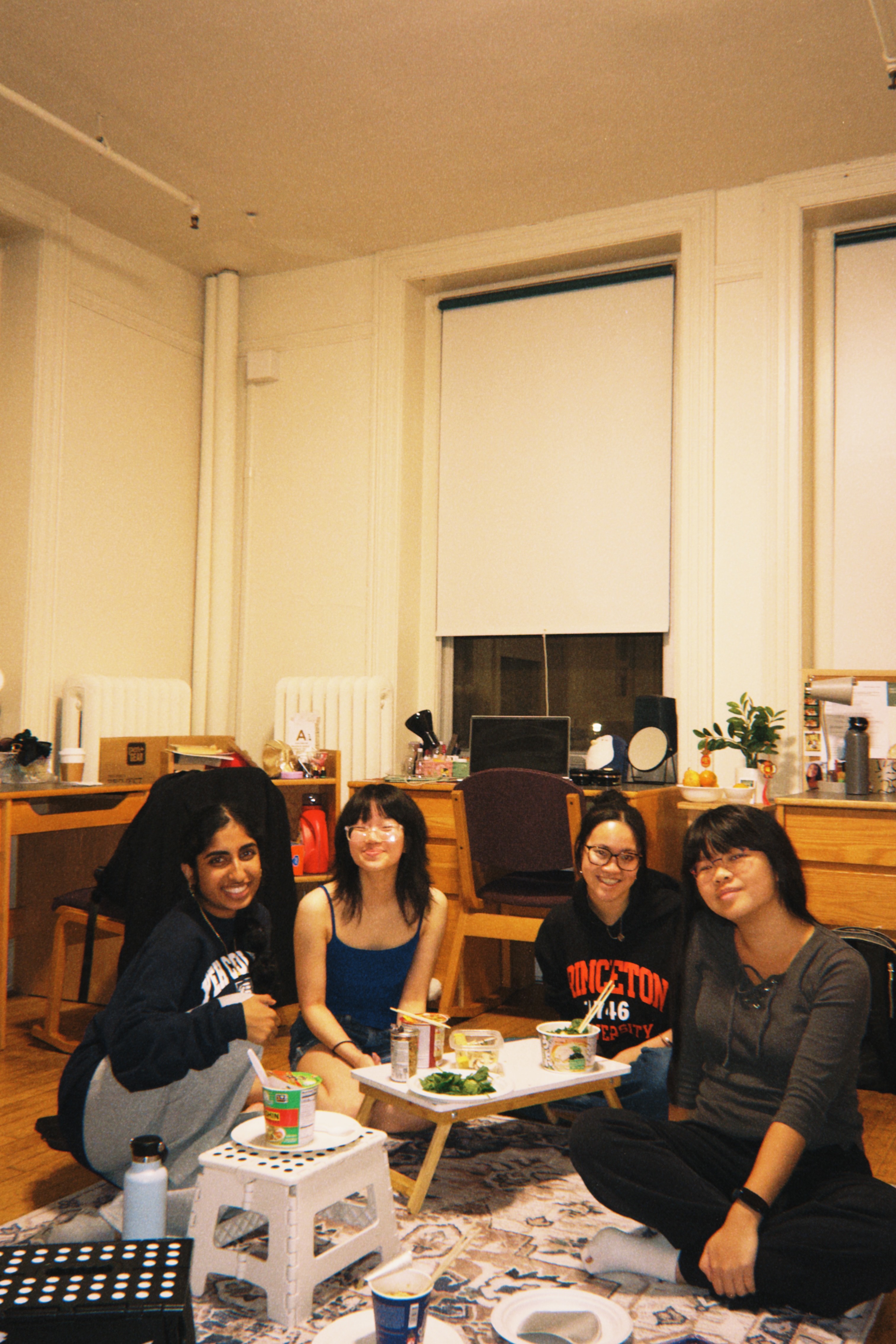 four students have a dorm room picnic