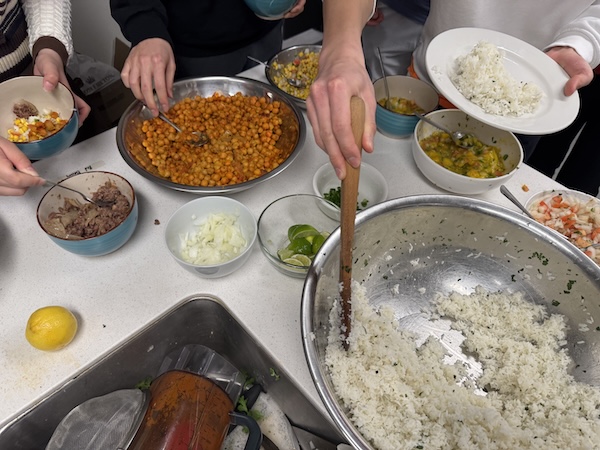 People serving themselves with bowls of food.