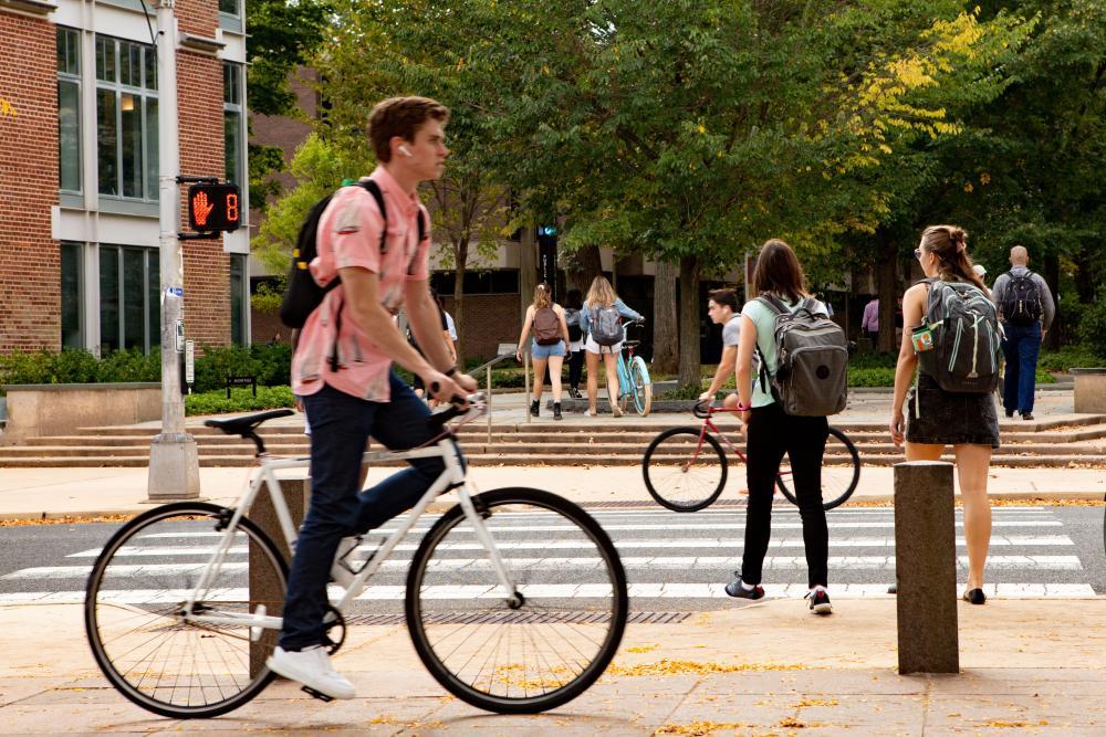 A student riding his bike through campus