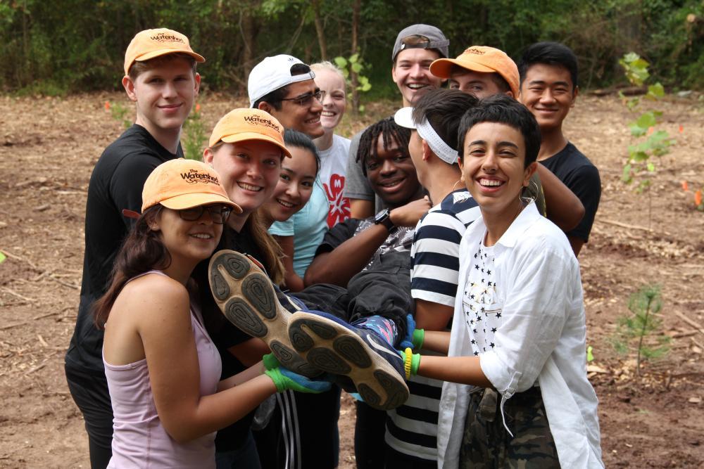Students carrying a classmate while on a service trip