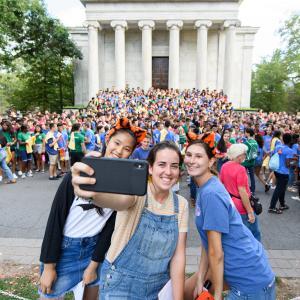 Students taking a selfie in front of a crowd
