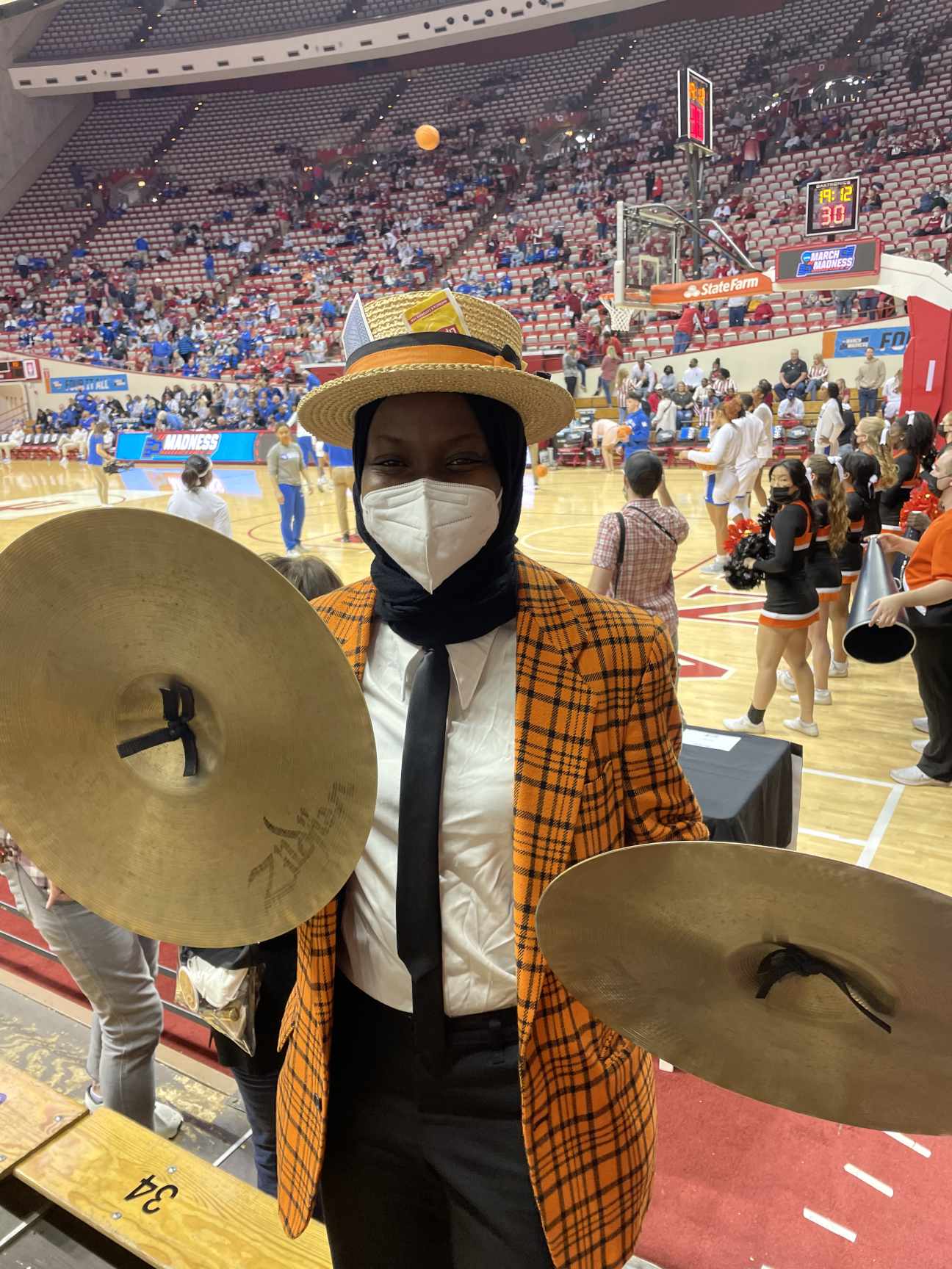 Aminah on a basketball court with cymbals in her hand