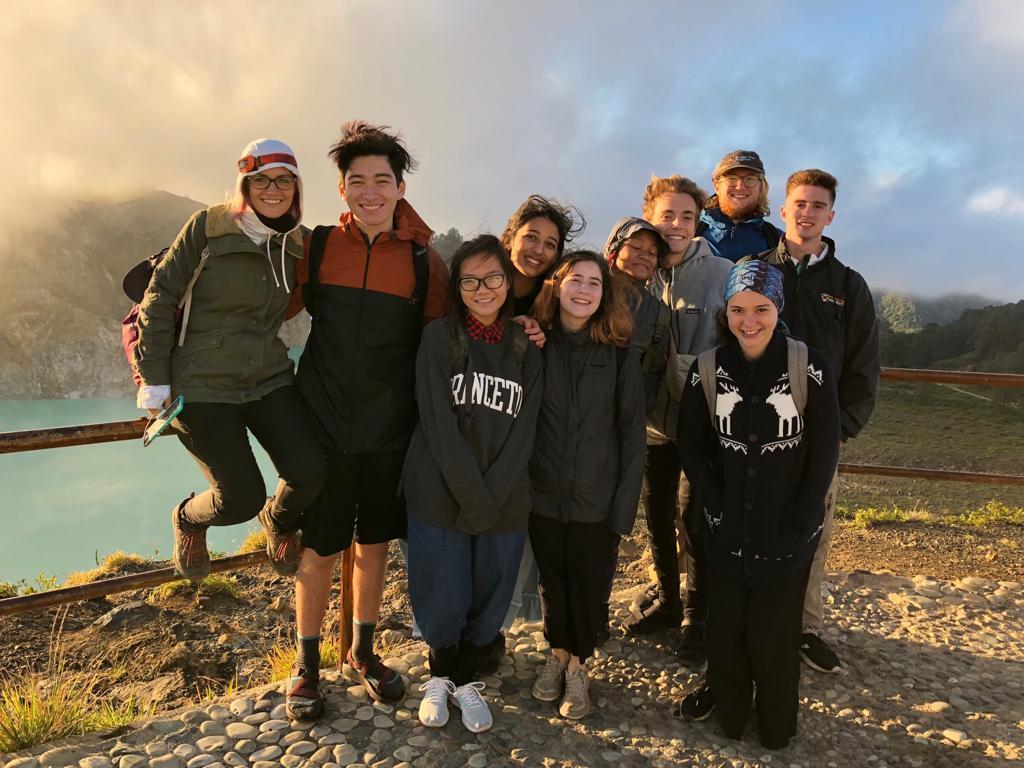 Group of students pose in front of a fence at a scenic overlook